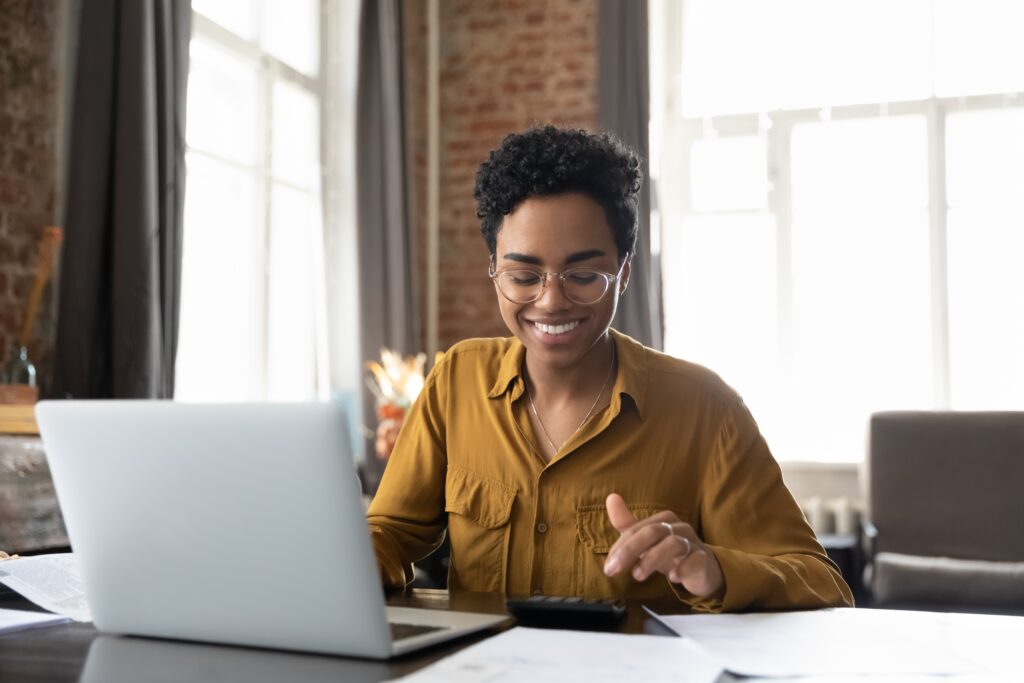 woman smiling on computer and calculator